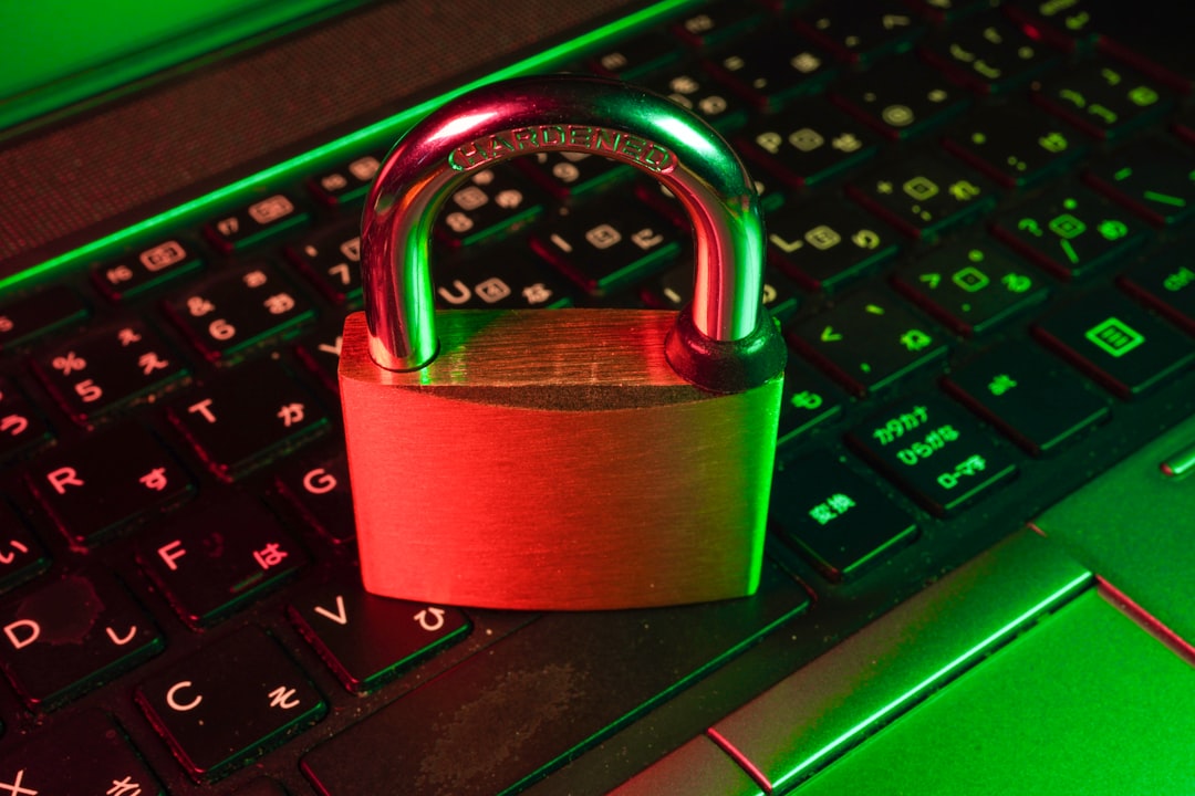 A close-up of a padlock resting on a laptop keyboard, illuminated with green and red lighting