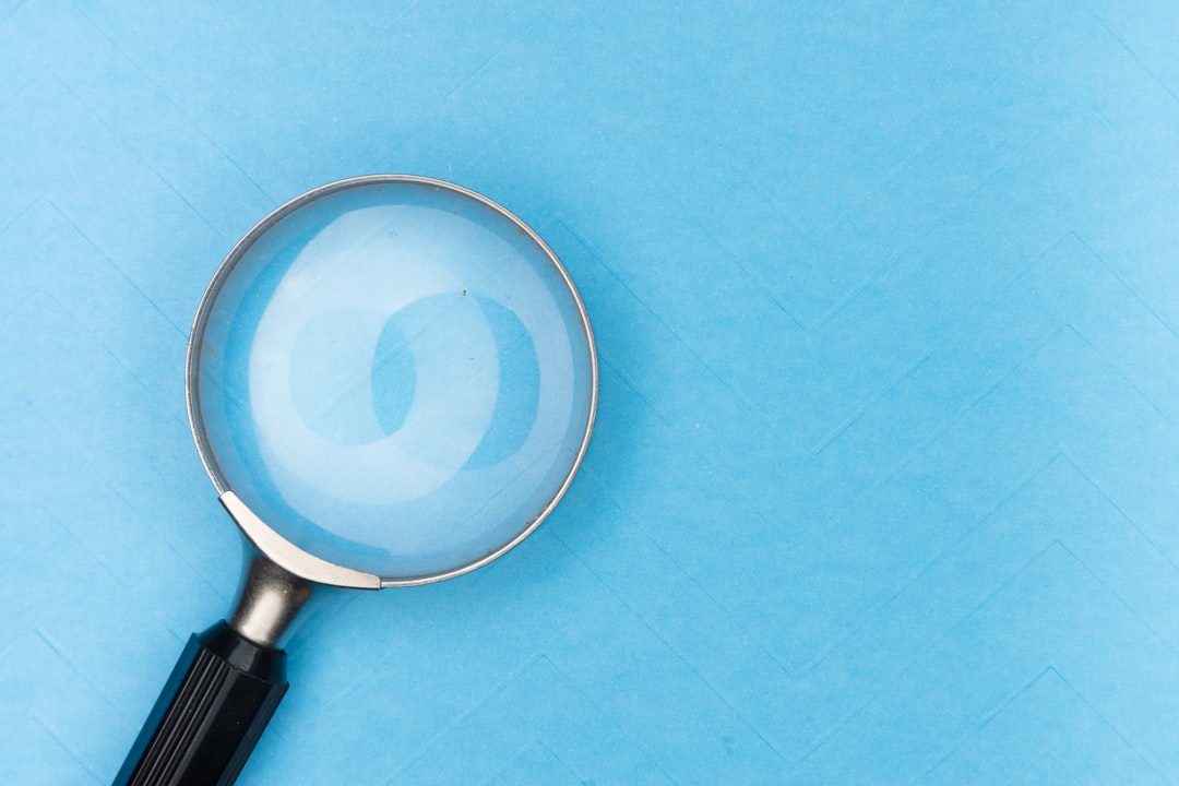 A magnifying glass on a blue background with a textured pattern.