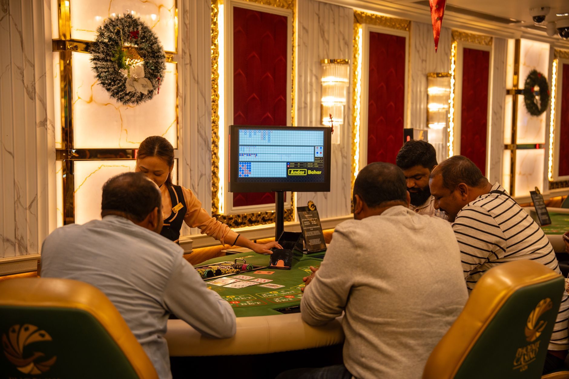 A group of adults playing at a casino table in Goa, India, captured indoors with festive decor. — 4rabet Online Casino Offeri