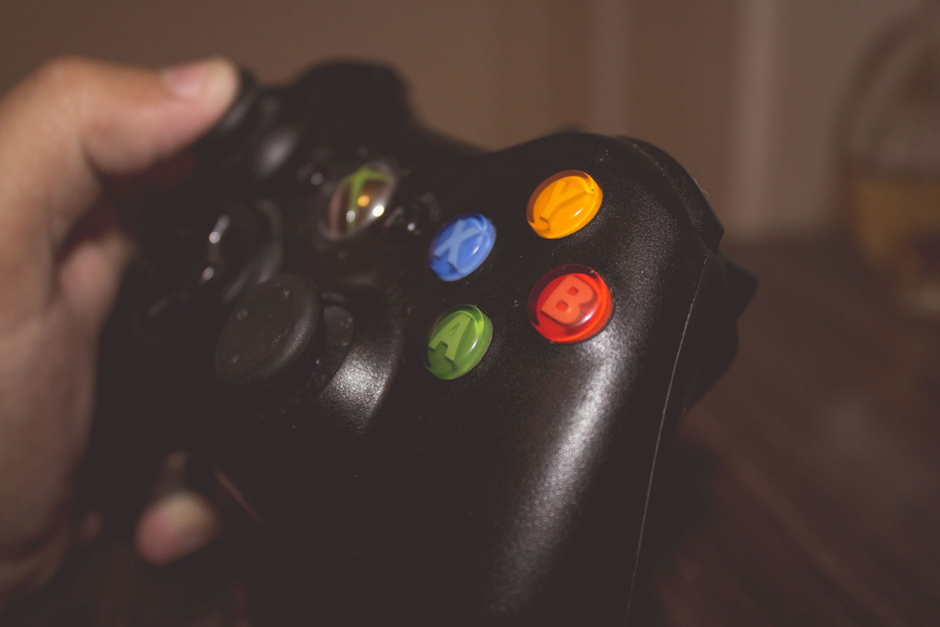 Close-up image of a hand holding a gaming controller with colorful buttons. — Access a Wide Range of Slots Instantly with Sol