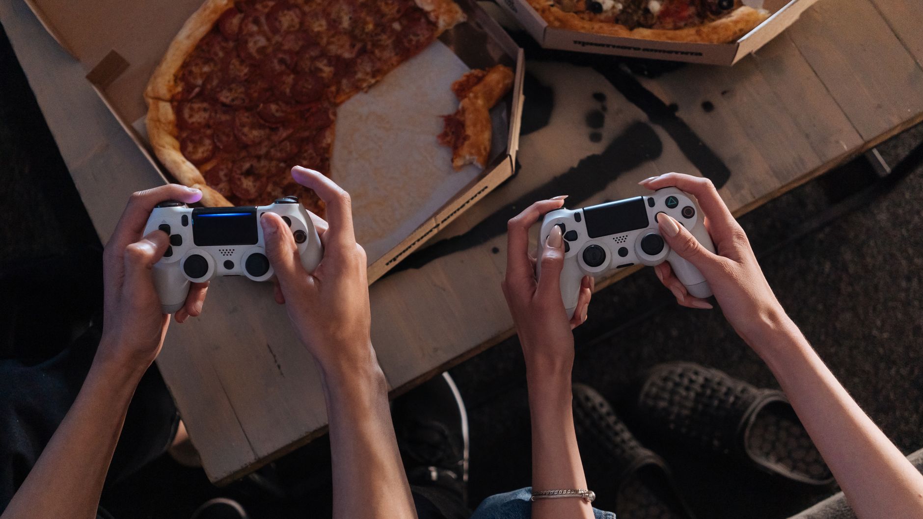Two people enjoying a gaming session with pizza, creating a cozy and fun atmosphere. — Baccarat Betting Systems: Smart Strate