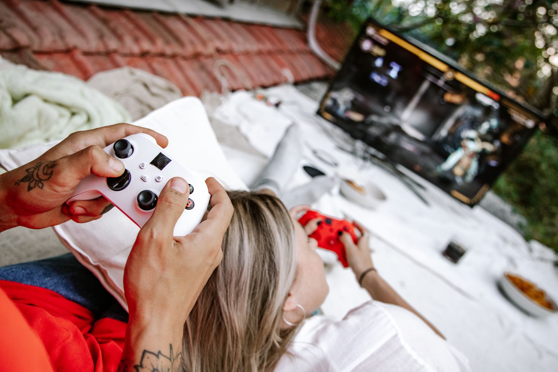 A couple playing video games outdoors, focusing on the controllers and screen. — BPLAY555 Creates an Exciting Environment for