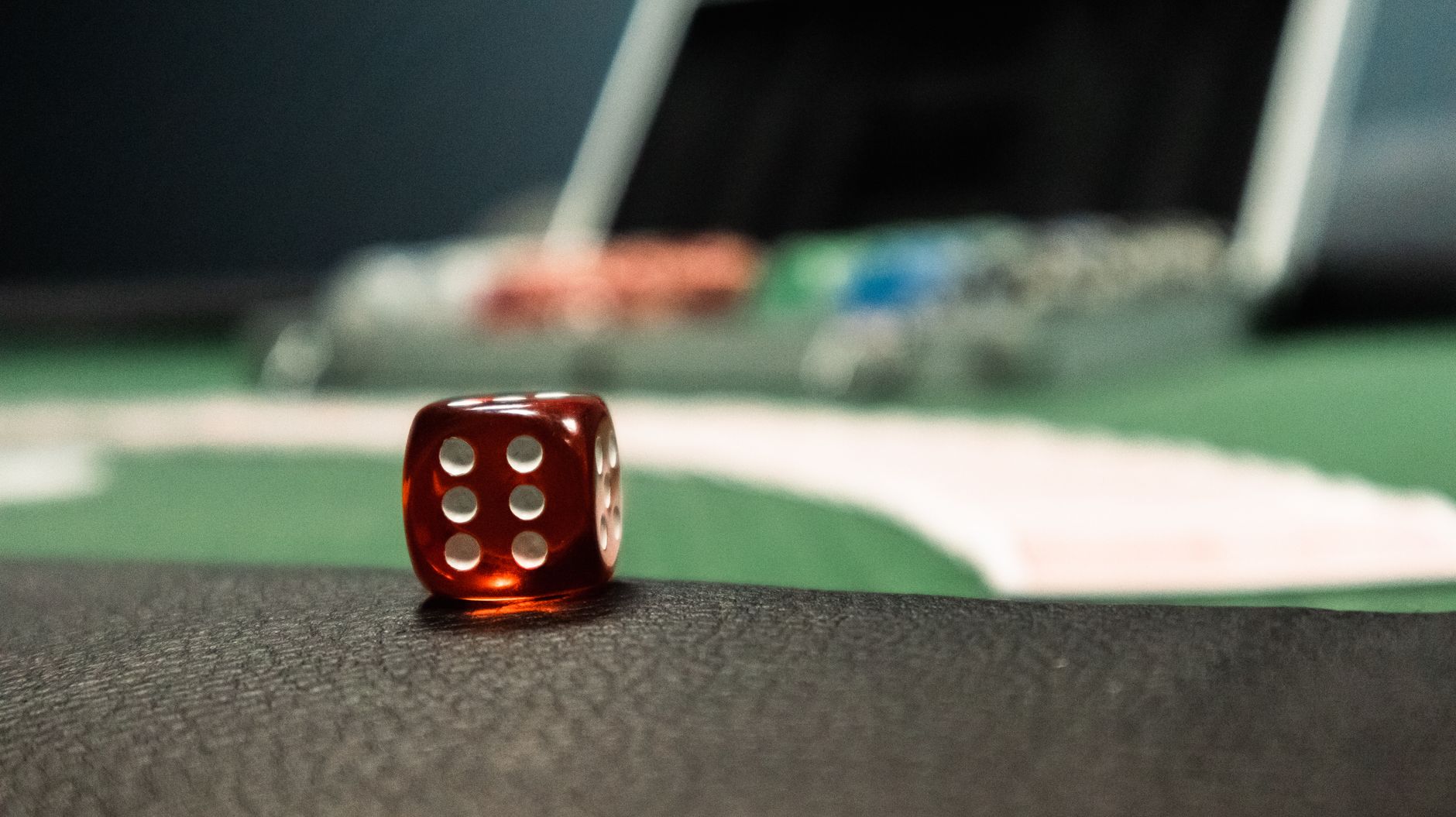 A close-up of a red dice on a casino table, evoking a sense of gambling excitement. — Choosing a Reliable Baccarat Site for O