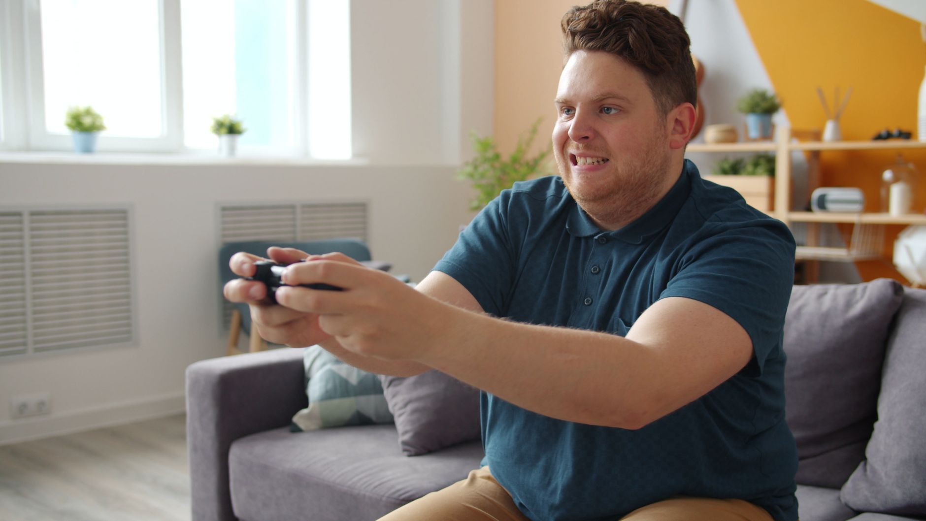 Man intensely focused on playing video games in a comfortable living room setting. — Discover the Most Engaging Free Online G