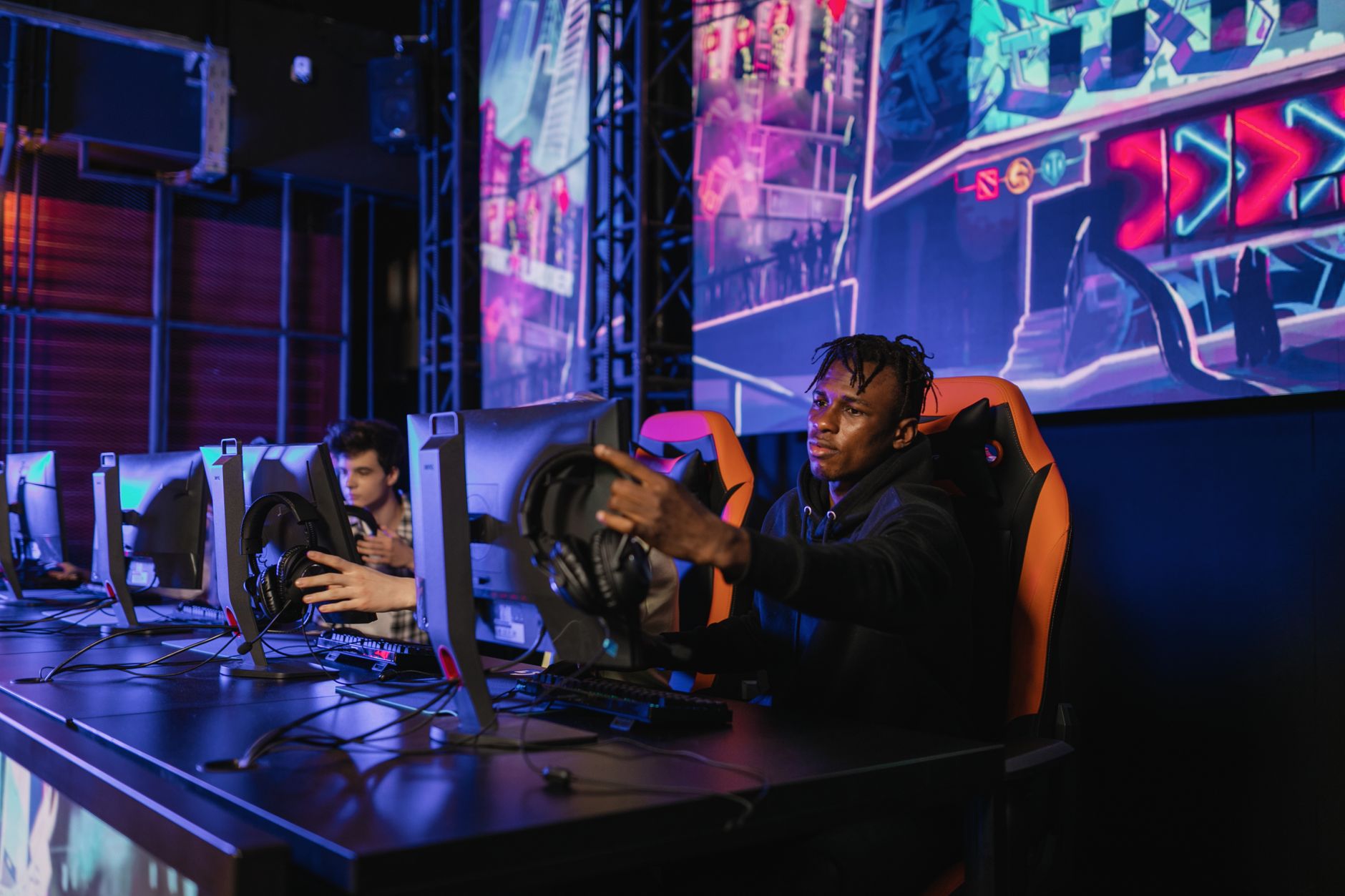 Two gamers intensely focused in a professional eSports competition with vibrant game visuals. — Eat and Run Verification Supp