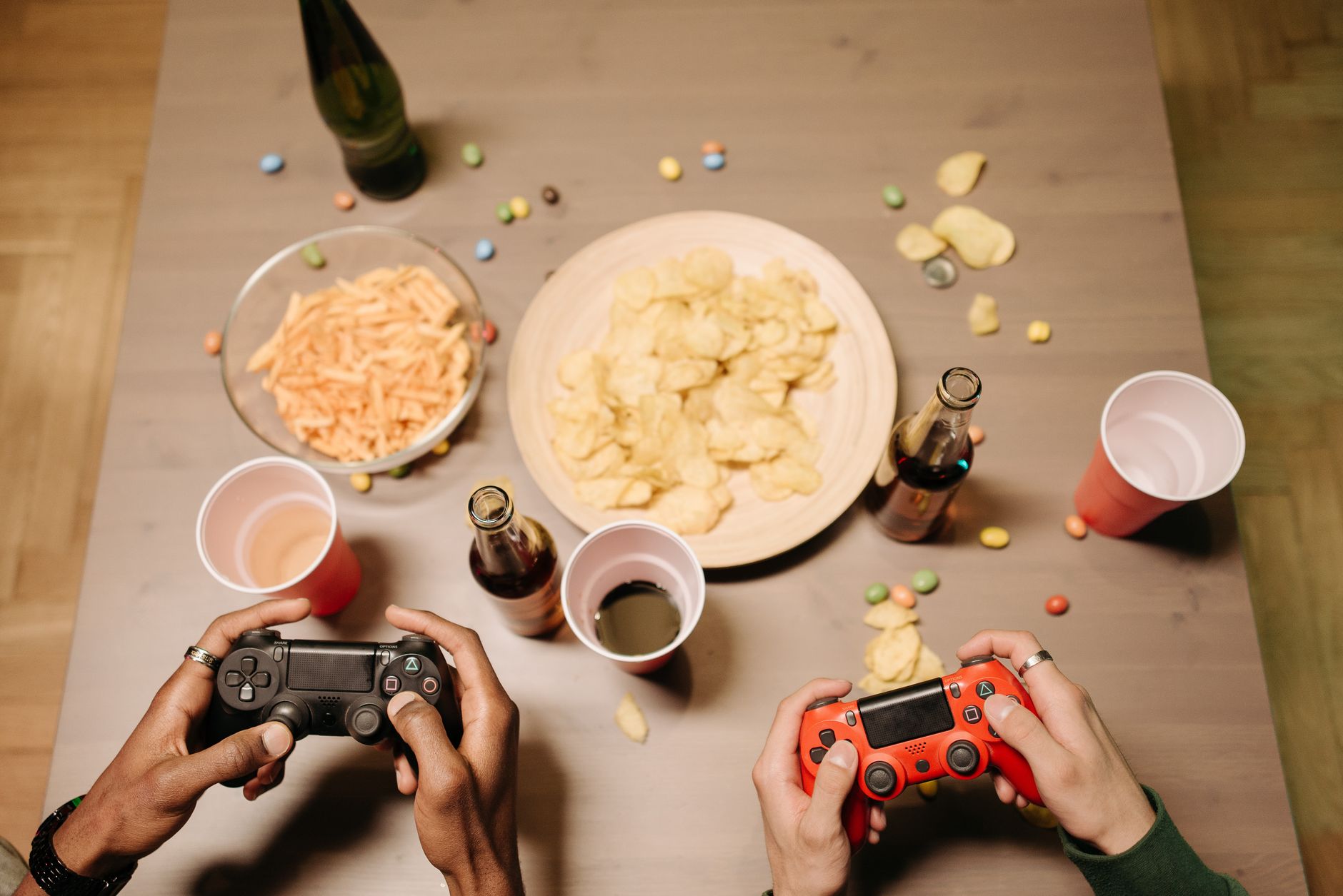 Two gamers playing video games with snacks and drinks on table, a perfect setup for gaming night. — Enjoy Daily Casino Action
