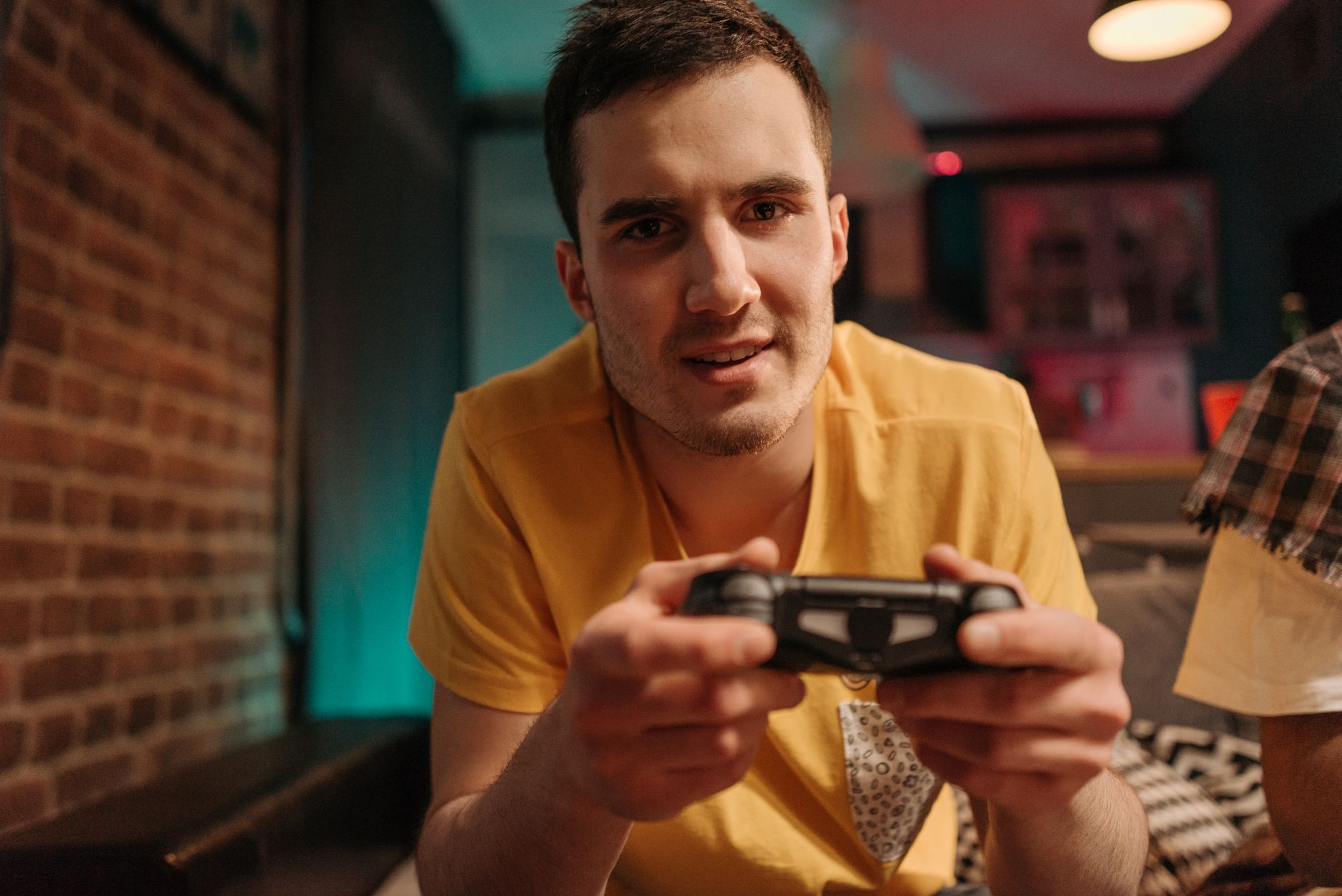 Focused young man enjoying video games with a controller indoors. — Experience Seamless Gaming with User-Friendly Slot Interf