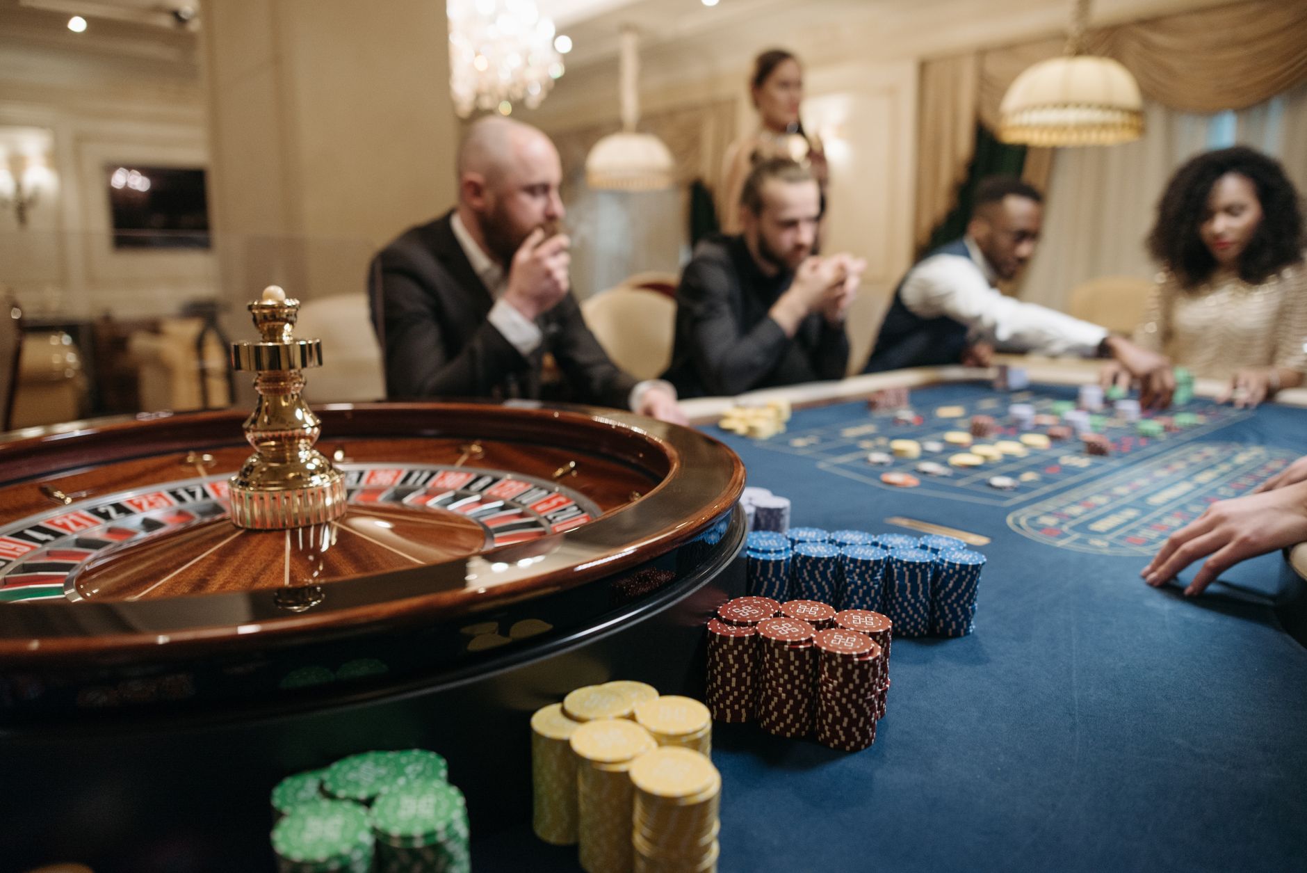 People enjoying a roulette game in an upscale casino setting with chips and a roulette wheel. — How LigaCiputra Rewards Loyal