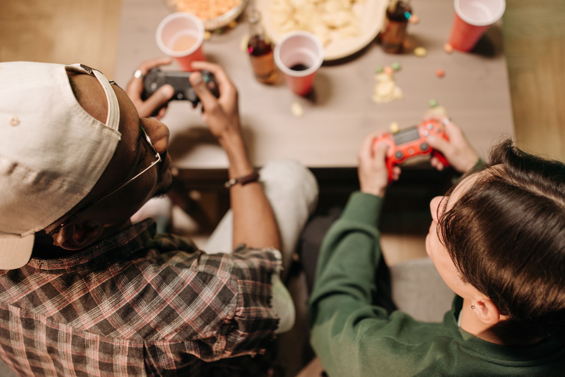 Two friends playing video games with controllers, sharing a fun indoor experience. — How Toto Sites Assist in Identifying Tru