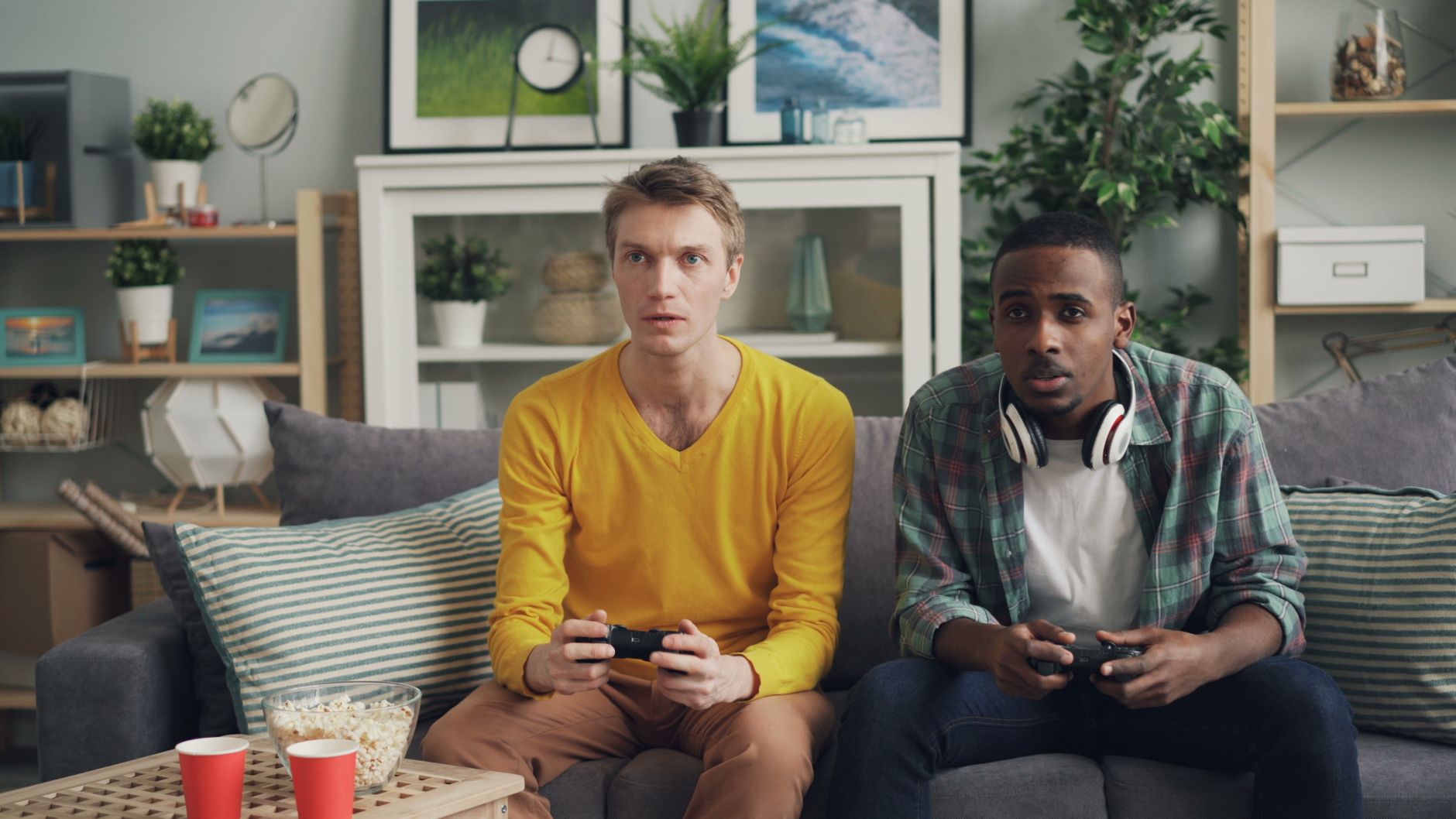 Two friends focus on gaming while relaxing on a couch in a modern living room. — Key Services Offered by W888 Online