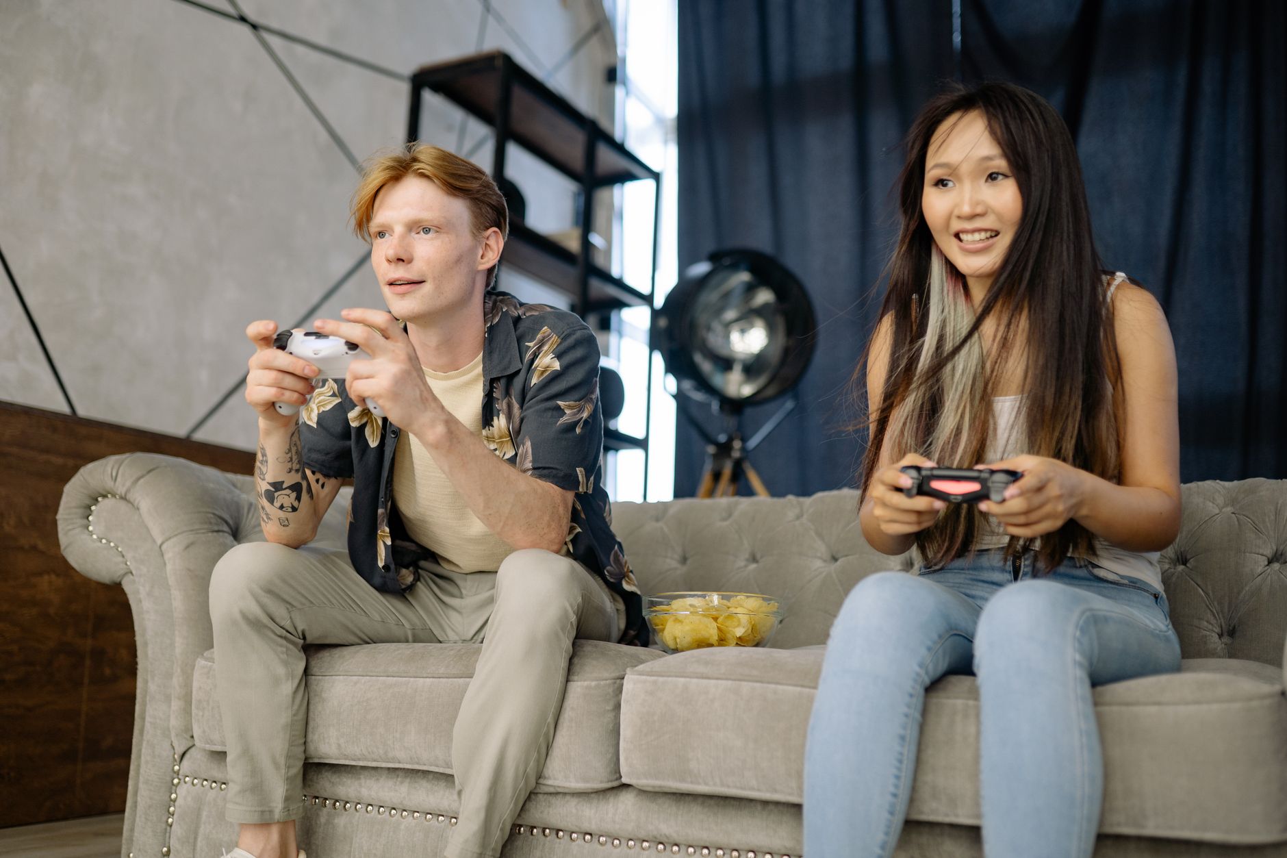 Two friends engaged in video gaming at home, enjoying leisure time on a comfortable couch. — KOMBO88: The Ultimate Destinatio