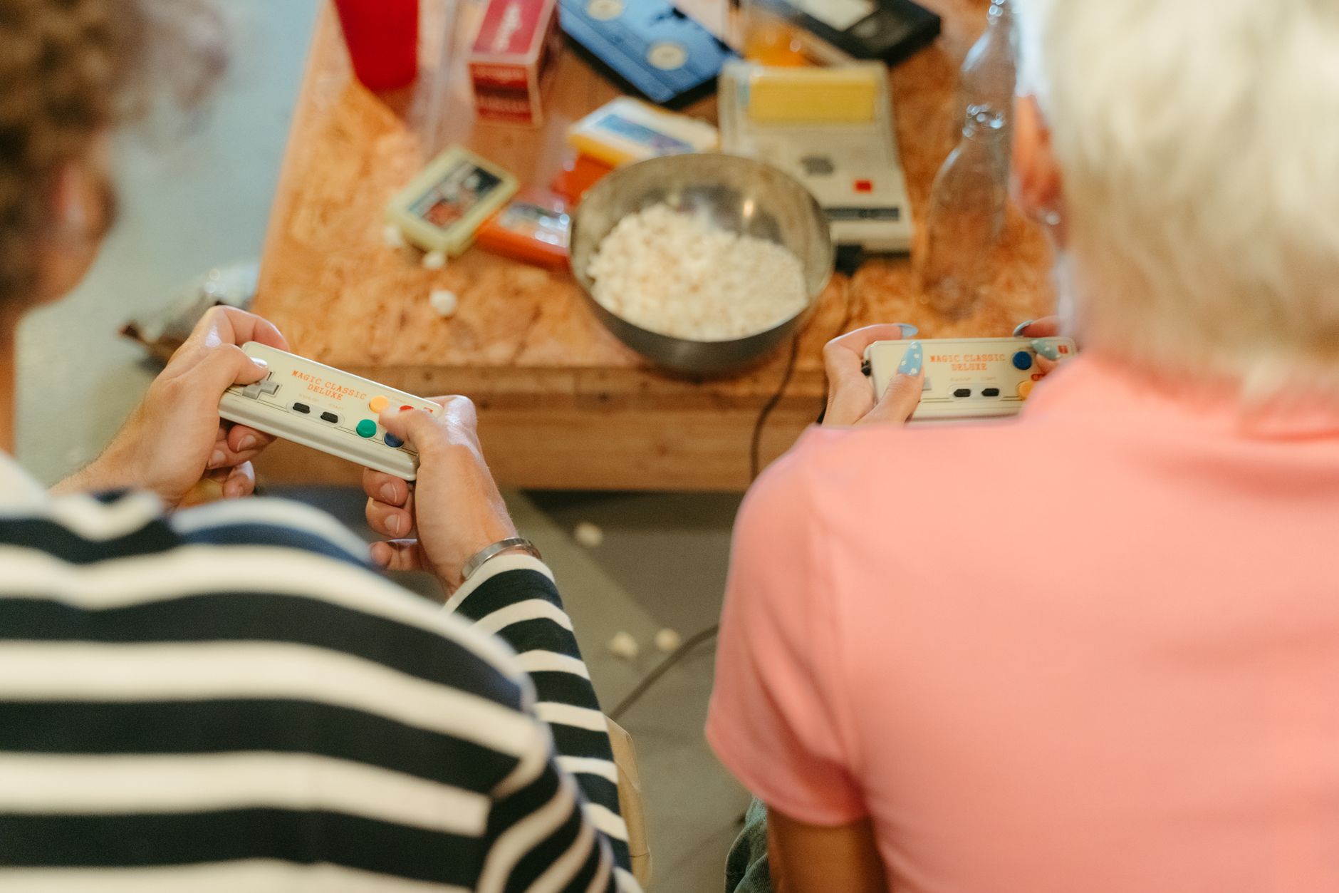 Two teenagers play video games together with snacks, creating a fun indoor atmosphere. — mpoid alternative link - Verified Ba