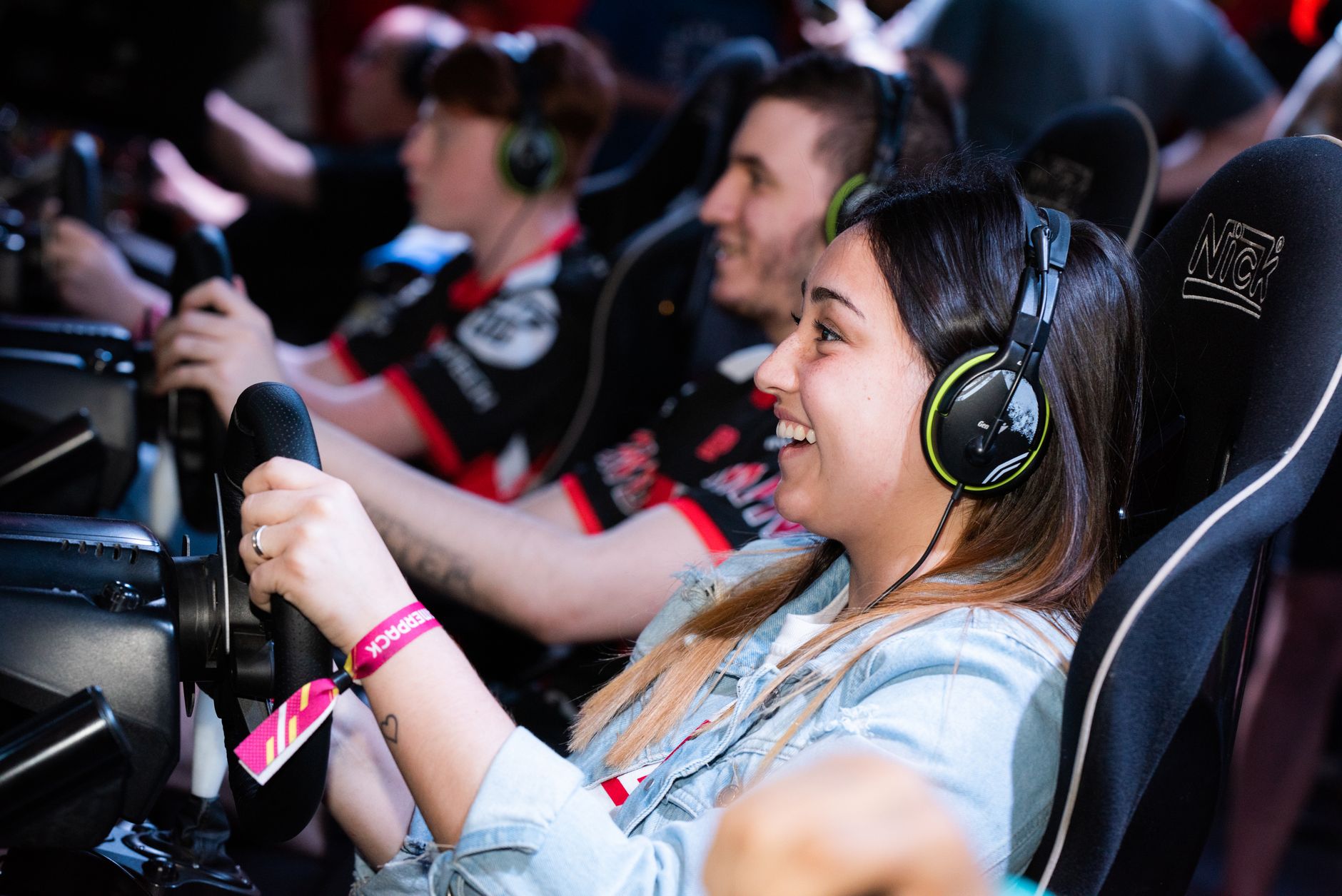 A group of people enjoying an immersive gaming experience at an e-sports center with headphones and steering wheels. — Naviga