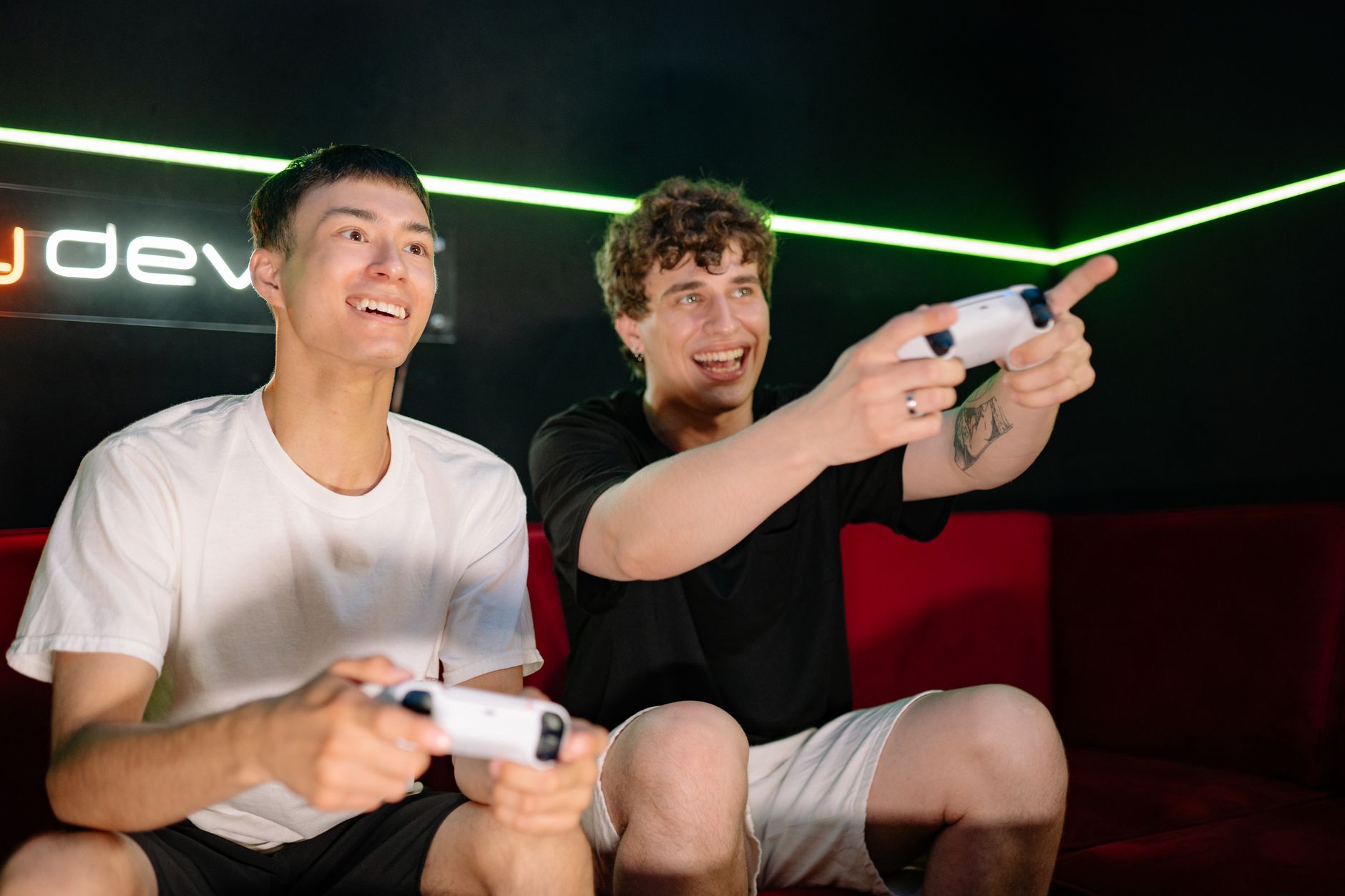 Two young men playing video games indoors, having fun and engaging with controllers. — Online Lottery: More Betting Options f