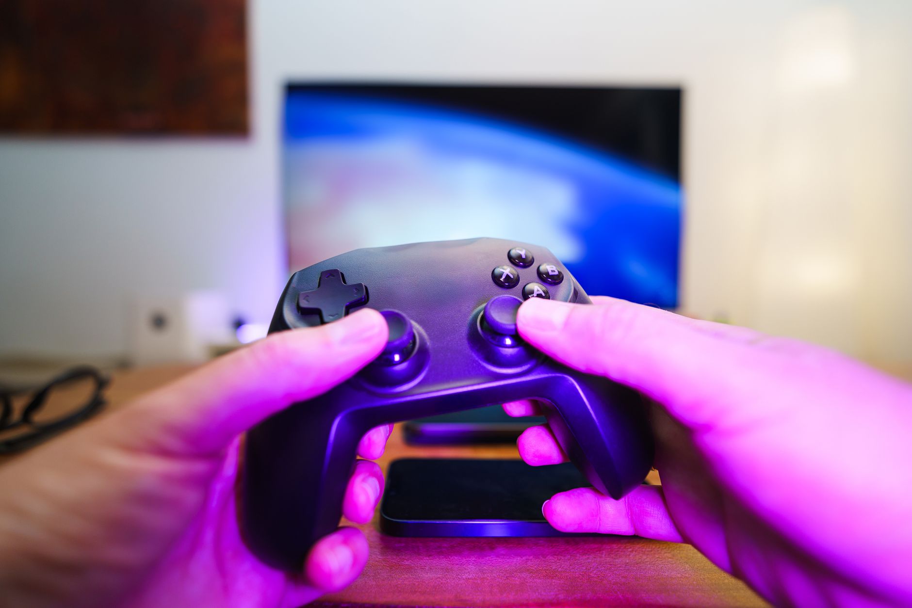 Close-up of hands holding a game controller in front of a TV screen. Perfect for entertainment setups. — Slot Easy Win Choice