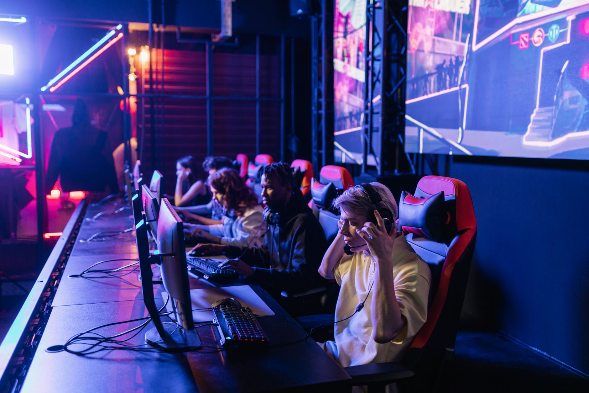 Focused gamers in a high-tech arena compete intensely, showcasing esports fervor. — Slot Online: The Perks of Virtual Reel Sp