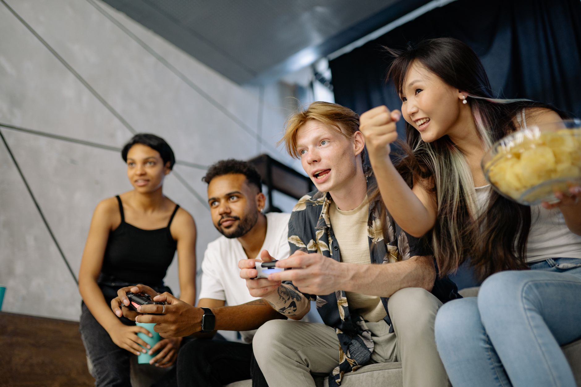 Four friends gaming enthusiastically inside a modern home, enjoying a lively moment. — Sweet888 Enhancing Player Engagement w