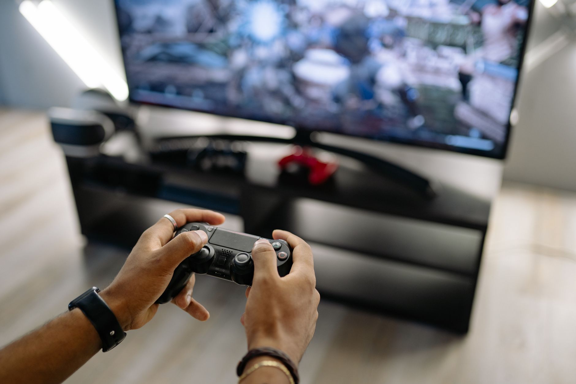 Close-up of hands holding a gaming controller while playing video games indoors. — The Secrets Behind Winning Jackpots on TC