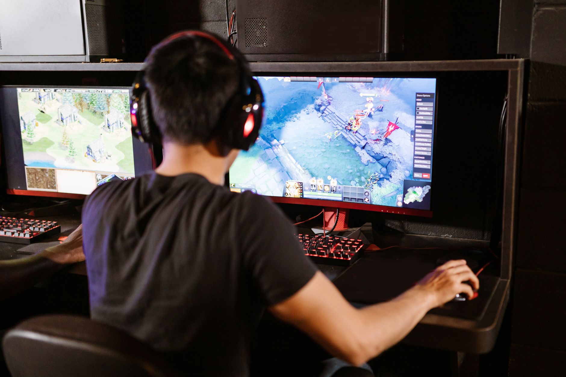 Adult male gamer immersed in PC gaming on dual monitors with headphones indoors. — Vivatbet: Competitive Odds for Maximum Pay