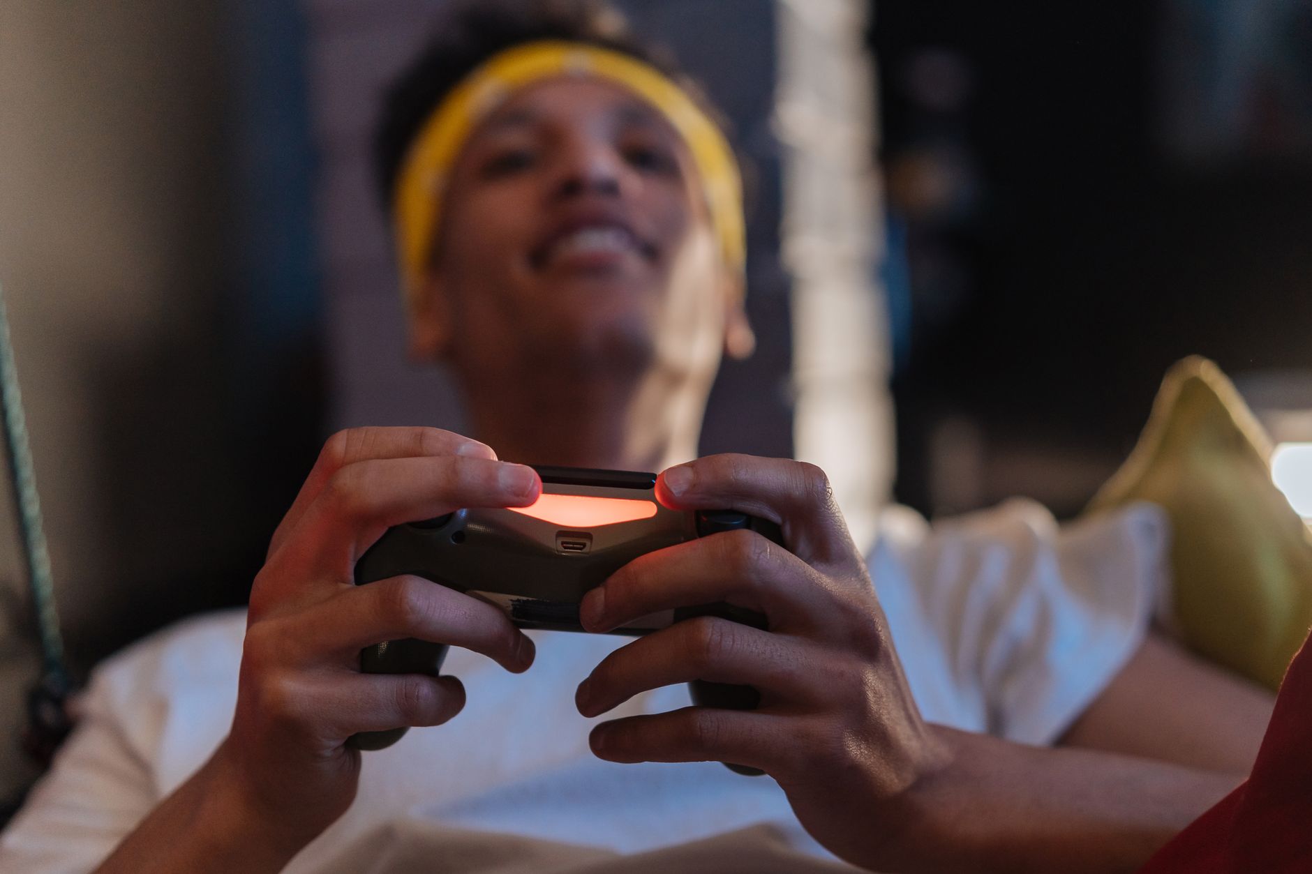 A relaxed gaming session with a close-up view of a man holding a game controller indoors. — Why Playing Gacor Slot Today Can