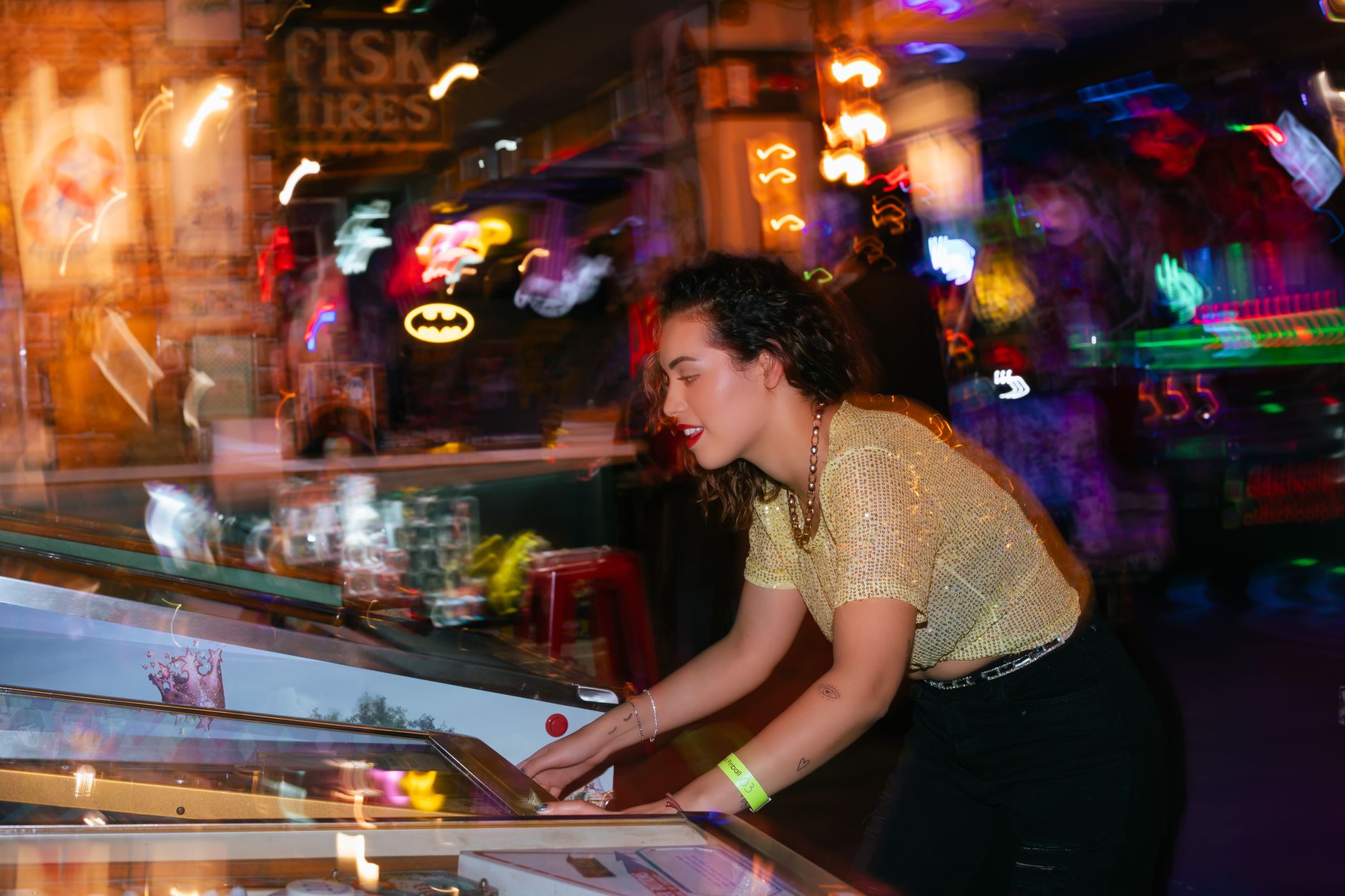 Young woman enjoying a night out playing pinball in an energetic arcade setting. — Why Toto TV is a Valuable Resource for Bet